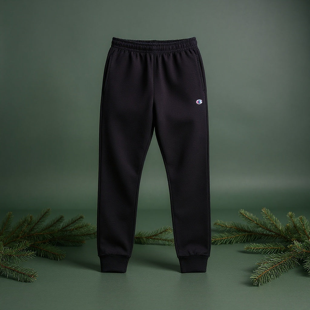 Black sweatpants with a small logo on a green background
